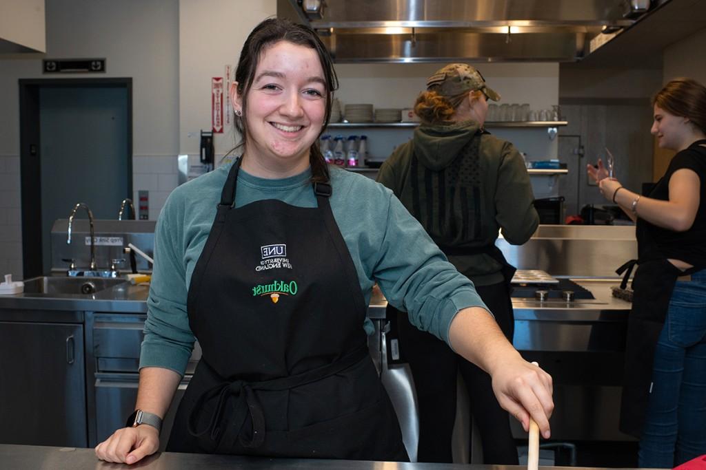 A nutrition smiles while they stir batter