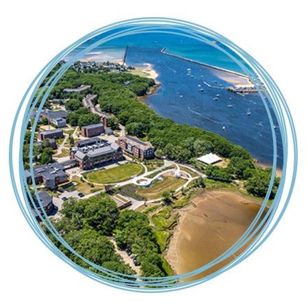 An aerial view of the Biddeford Campus featuring brick buildings, the Saco River, and Atlantic Ocean