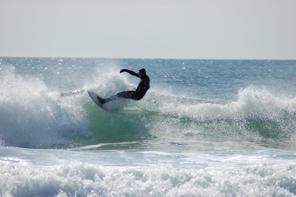 A member of the U N E surf club catches a wave