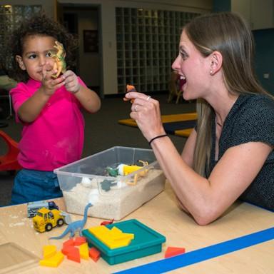 U N E student working with toddler