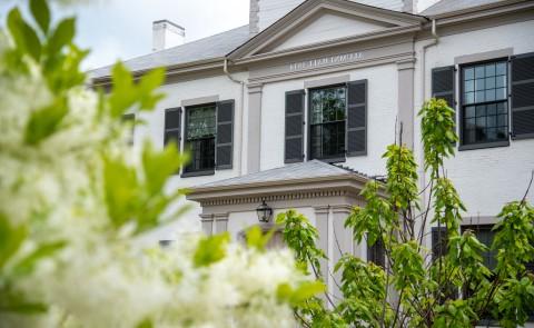 A photo of flowers on the Portland Campus with 校友 Hall in the background