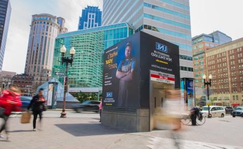 A UNE advertisement adorns a subway entrance in downtown Boston, Mass.