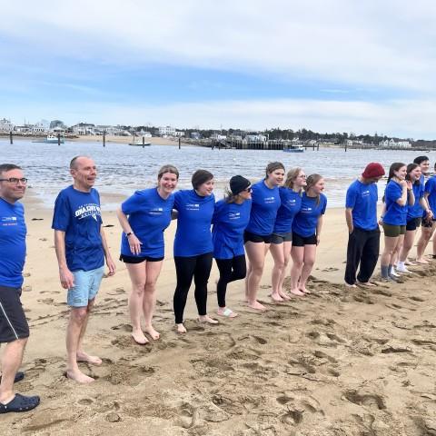 Members of the UNE community line up on Freddy Beach to jump into the Saco River